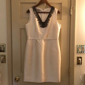 Knee length ivory dress with silver grey embellishments around the neck.